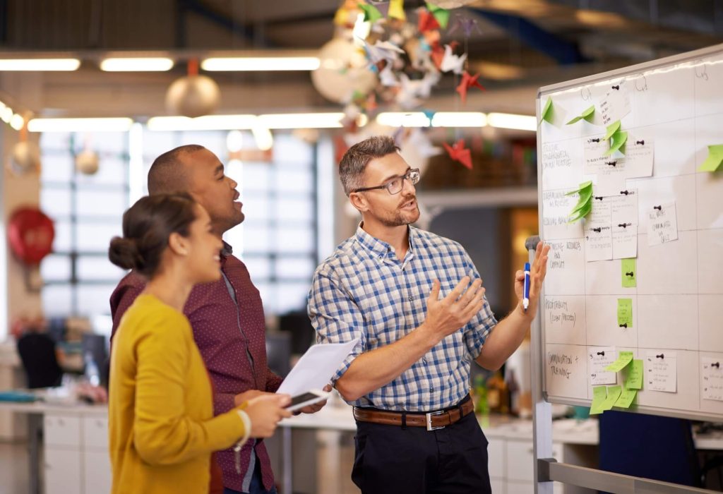 Digital marketing team discussing SEO content strategy at a whiteboard